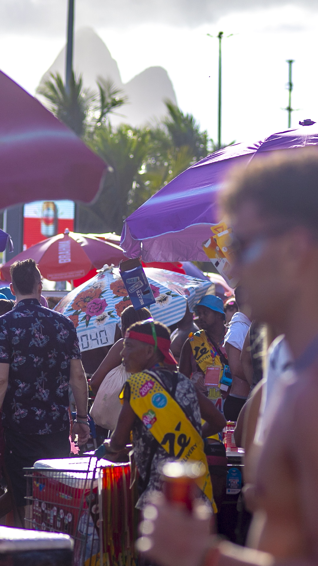 The parade is a burst of color, with vibrant costumes and umbrellas turning the beach into a moving canvas of joy.